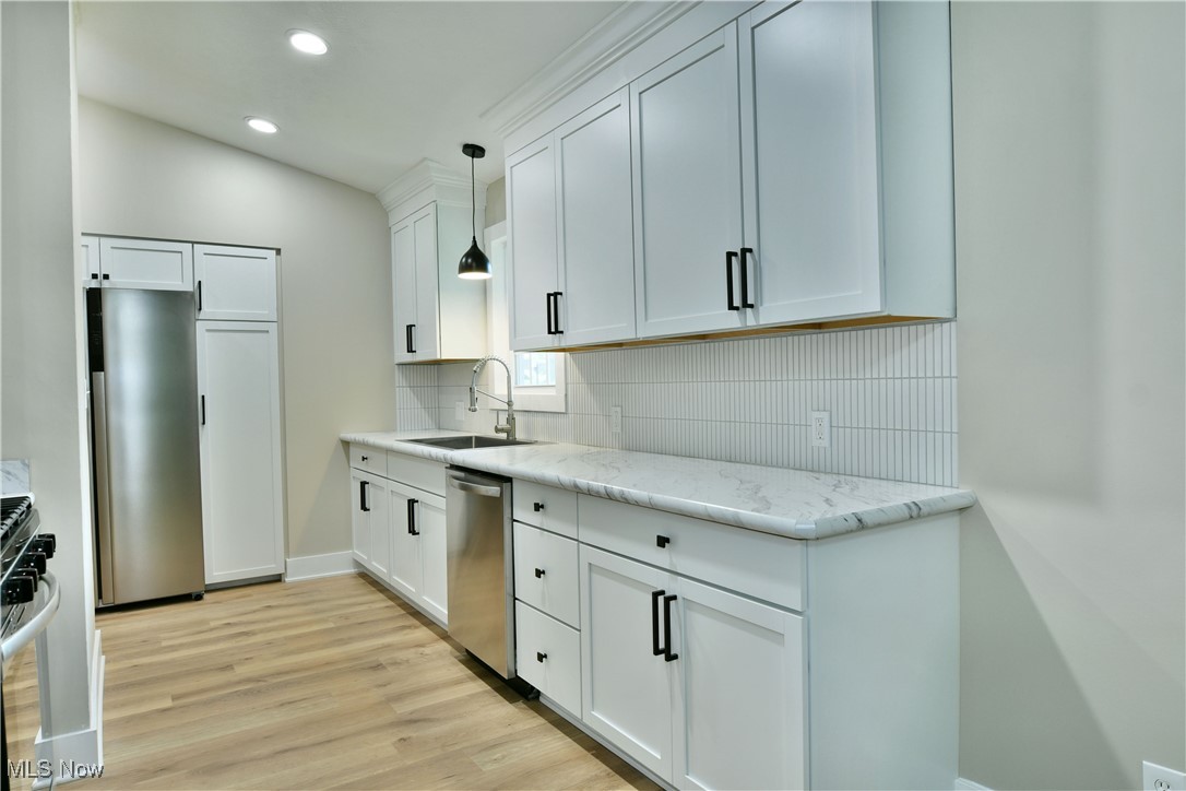 7655 Connelly Road Masury, OH 44438 - Photo 7 of 46 Kitchen with appliances with stainless steel finishes, tasteful backsplash, light wood-style flooring, recessed lighting, and white cabinets