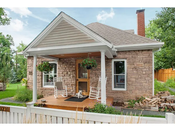 a view of a house with a small yard and wooden fence