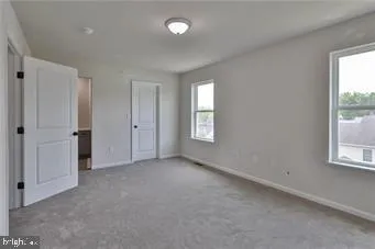 an empty room with windows and closet