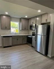 a kitchen with stainless steel appliances granite countertop a refrigerator a sink a stove a microwave and island