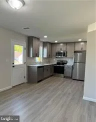 a kitchen with stainless steel appliances granite countertop a refrigerator a stove top oven a sink and dishwasher