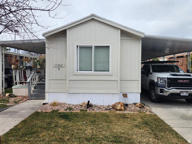 11362 Crescent Park Way, Unit 8 Sandy, UT 84070 - Photo 1 of 20 Manufactured / mobile home with an attached carport, a front lawn, and concrete driveway
