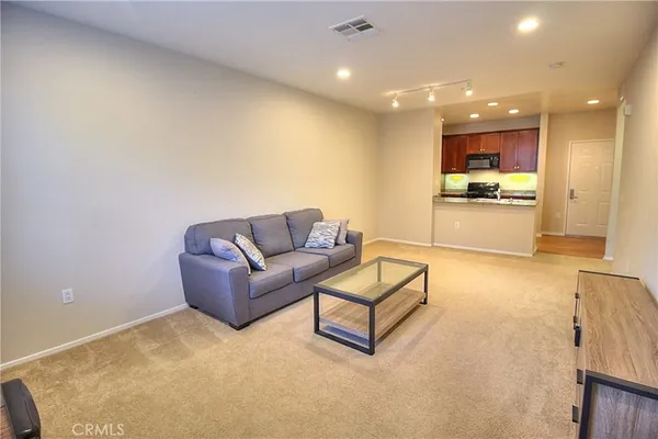 a living room with furniture and a kitchen