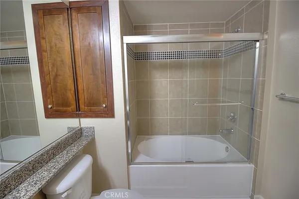 a bathroom with a granite countertop bathtub and a shower