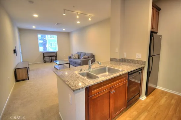 a dining hall with stainless steel appliances granite countertop a sink and dishwasher