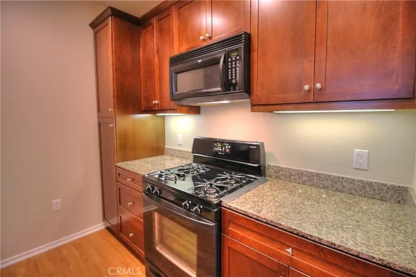 a kitchen with wooden cabinets and a stove top oven