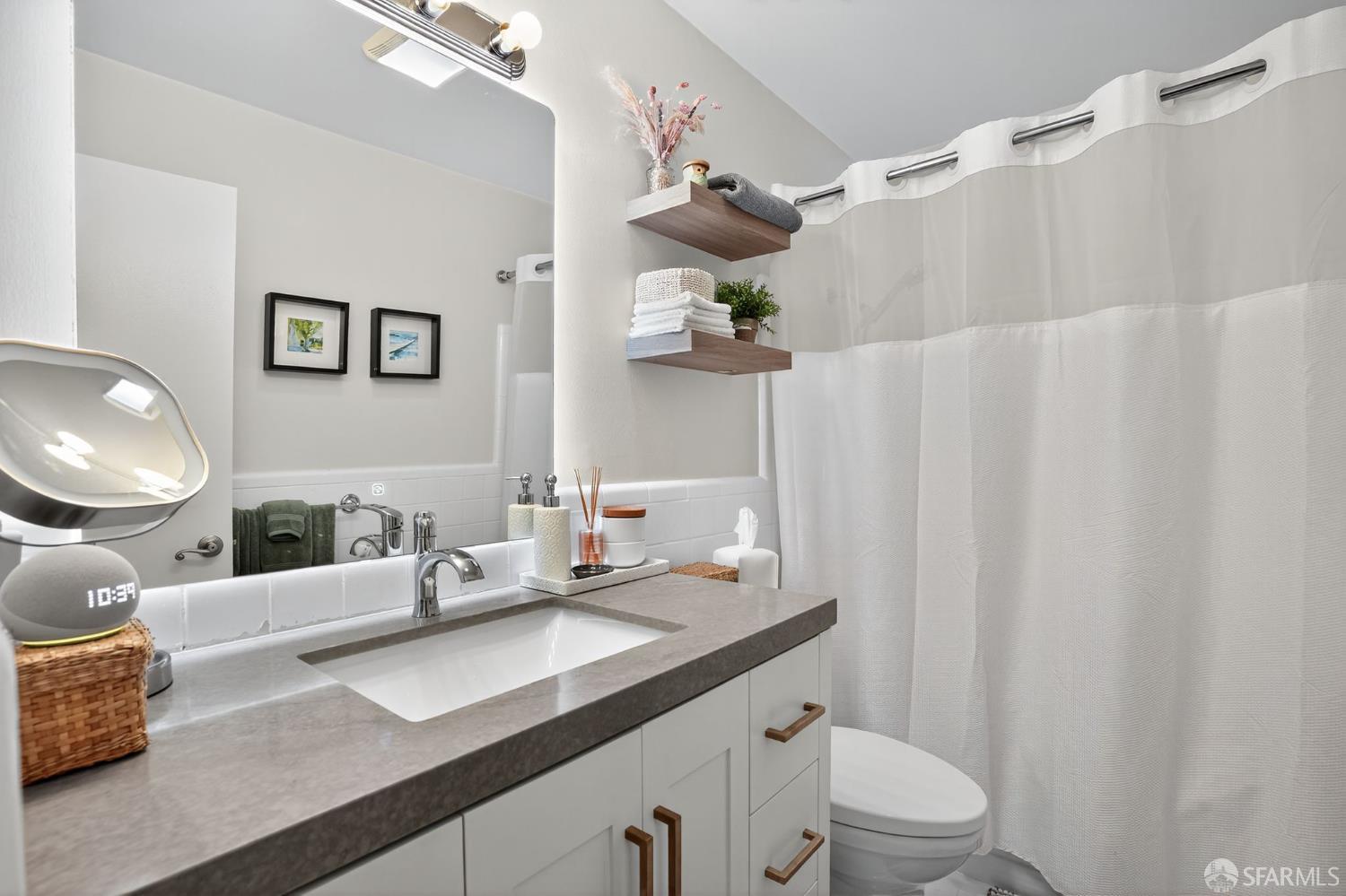 222 Laurel Street, Unit 109 San Carlos, CA 94070 - Photo 22 of 27 a spacious bathroom with a granite countertop sink a toilet and a mirror
