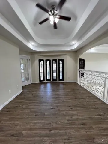 a view of an empty room with window and wooden floor