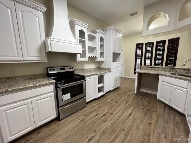 a kitchen with stainless steel appliances granite countertop a stove and cabinets