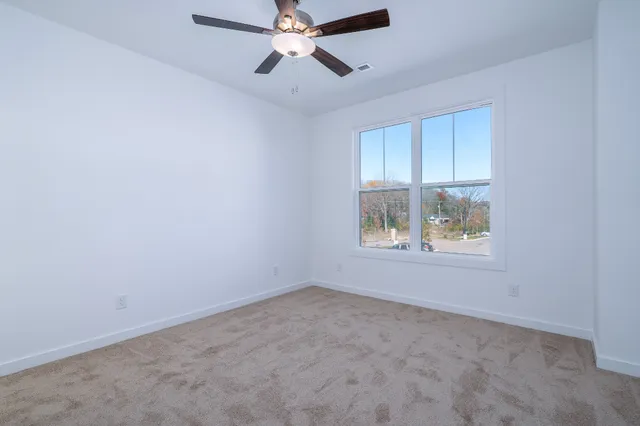 an empty room with a window and a fan