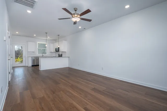 wooden floor in an empty room with a kitchen