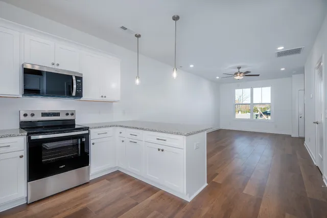 a view of kitchen with microwave stove top oven and cabinets