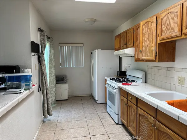 a kitchen with a refrigerator a sink dishwasher stove and oven