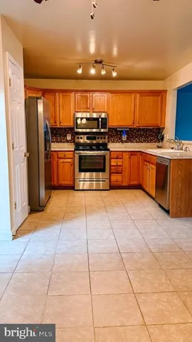 a kitchen with stainless steel appliances a stove a sink and a refrigerator