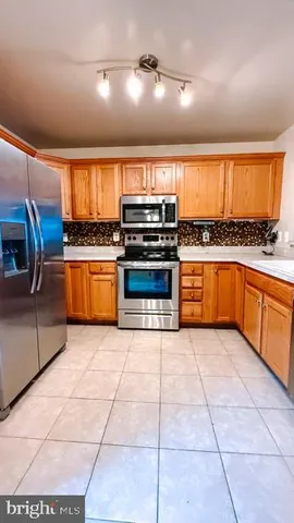 a large kitchen with stainless steel appliances granite countertop a stove and a sink
