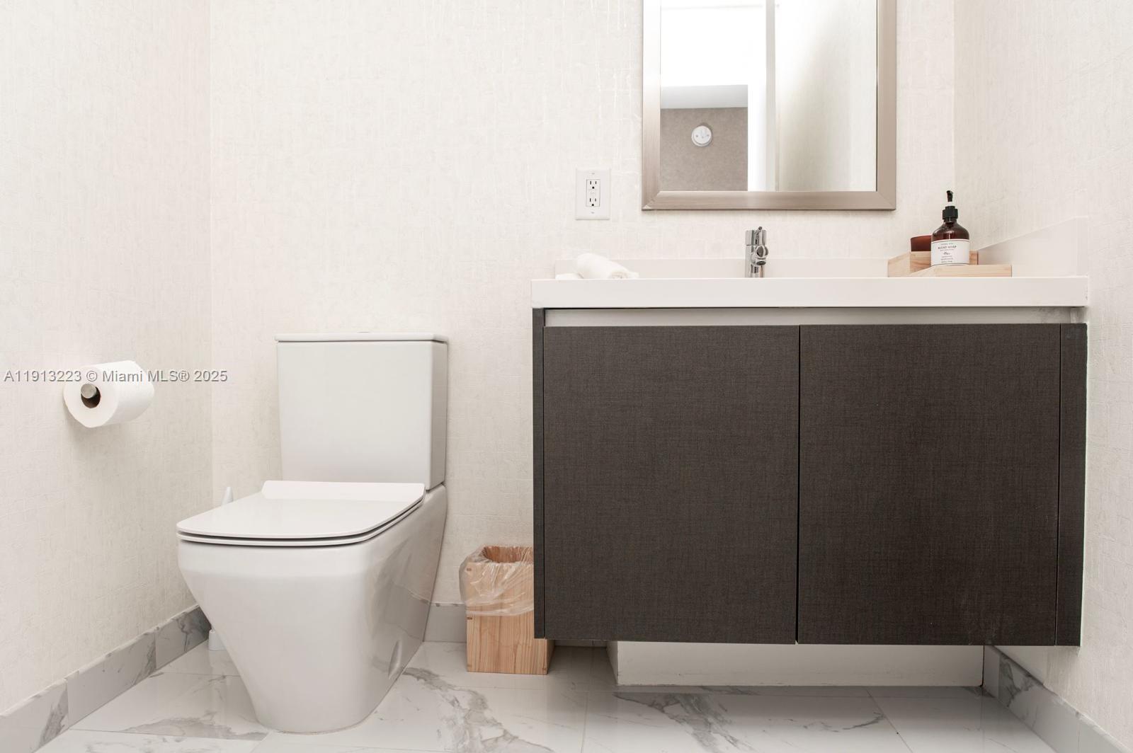 851 Northeast 1st Avenue, Unit 1811 Miami, FL 33132 - Photo 14 of 57 a bathroom with a toilet sink and mirror