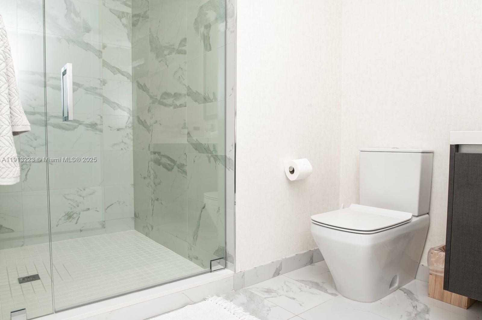 851 Northeast 1st Avenue, Unit 1811 Miami, FL 33132 - Photo 15 of 57 a white toilet sitting next to a bathroom