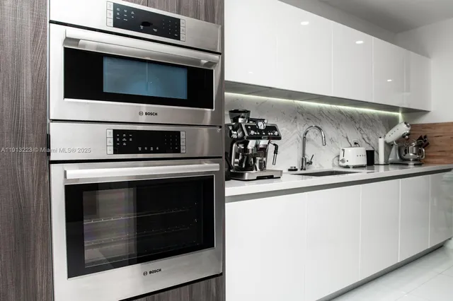 a kitchen with stainless steel appliances a stove microwave and sink