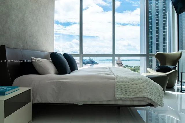 a bed sitting in a bedroom next to a large window