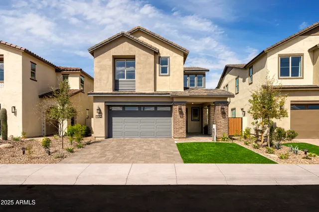 a view of a brick house with large windows and a yard