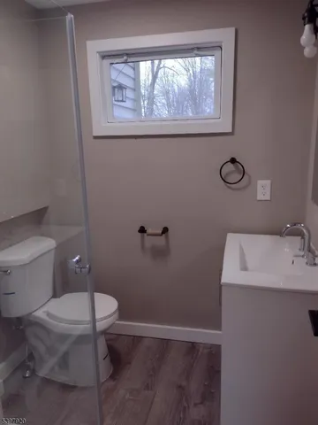 a bathroom with a toilet a sink and a window