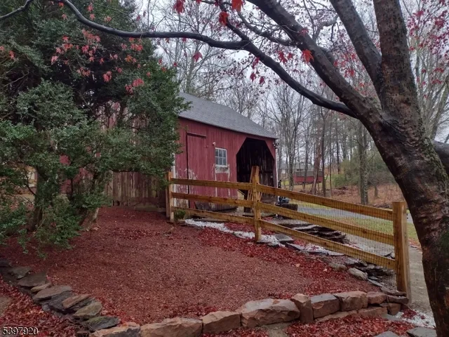 a view of backyard with wooden fence and a large tree