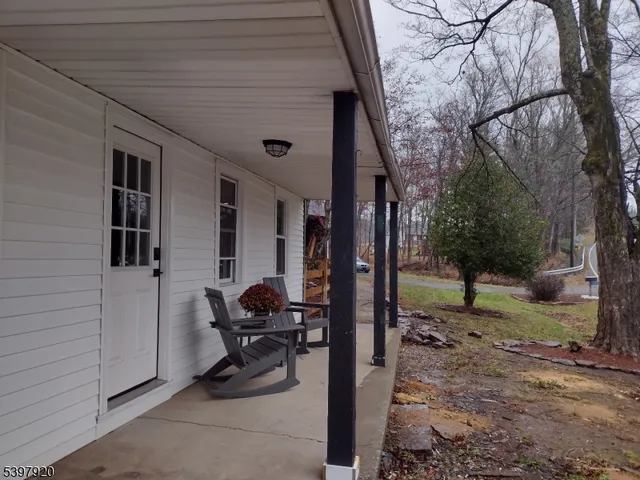 a view of a patio with table and chairs and floor to ceiling window
