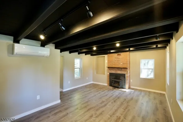 a view of an empty room with a fireplace and a window