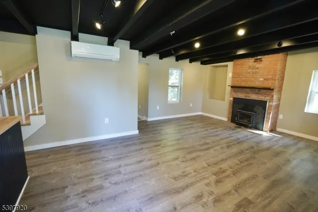 an empty room with wooden floor and fireplace