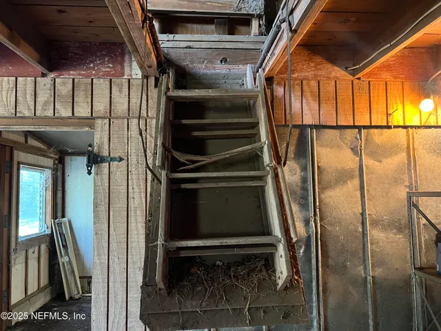 a view of an empty room with window and stairs