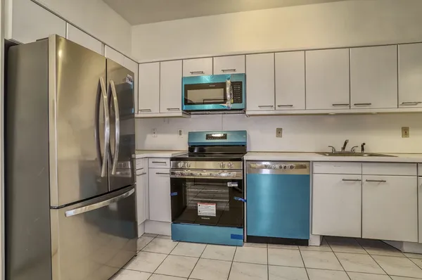 a kitchen with stainless steel appliances granite countertop a refrigerator and a stove