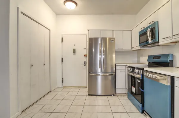 a kitchen with stainless steel appliances granite countertop a refrigerator and a stove top oven