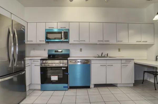 a kitchen with stainless steel appliances granite countertop a stove a sink and a refrigerator
