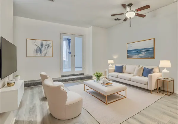 an empty room with wooden floor fan and windows