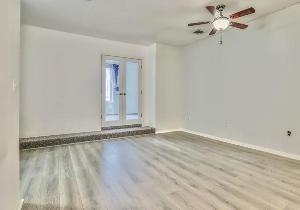 a view of empty room with wooden floor