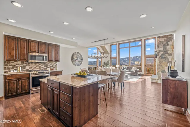 a dining room with furniture a rug and a floor to ceiling window