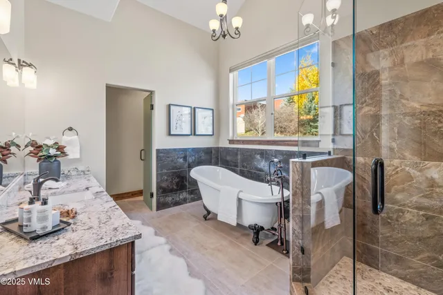 a bathroom with a granite countertop tub sink and mirror