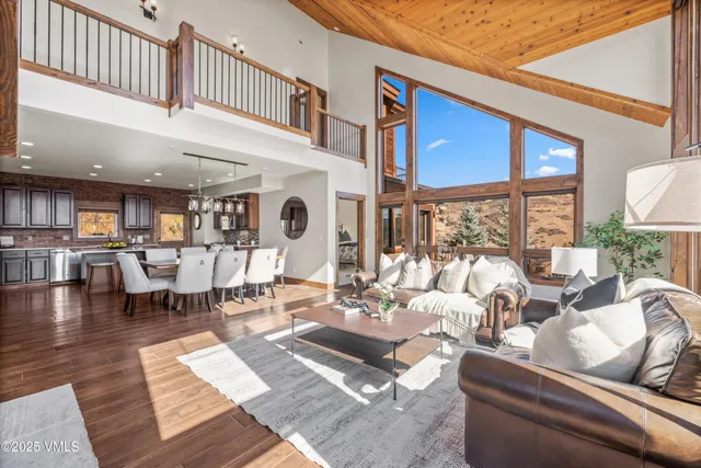 a living room with furniture a rug potted plant and a large window