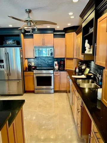 a kitchen with stainless steel appliances granite countertop a sink stove and refrigerator