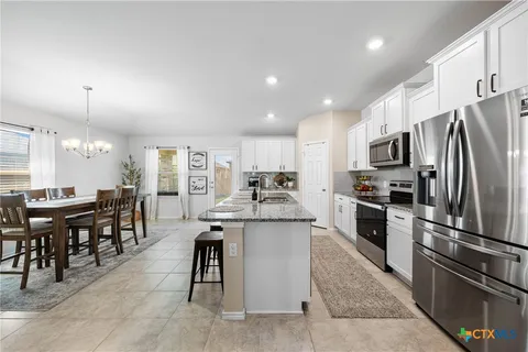 a kitchen with kitchen island a large counter top space and stainless steel appliances