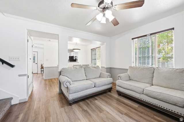 984 Independence Avenue Provo, UT 84604 - Photo 4 of 19 Living area featuring wood-finish flooring, a ceiling fan with integrated lighting, and a large window with blinds