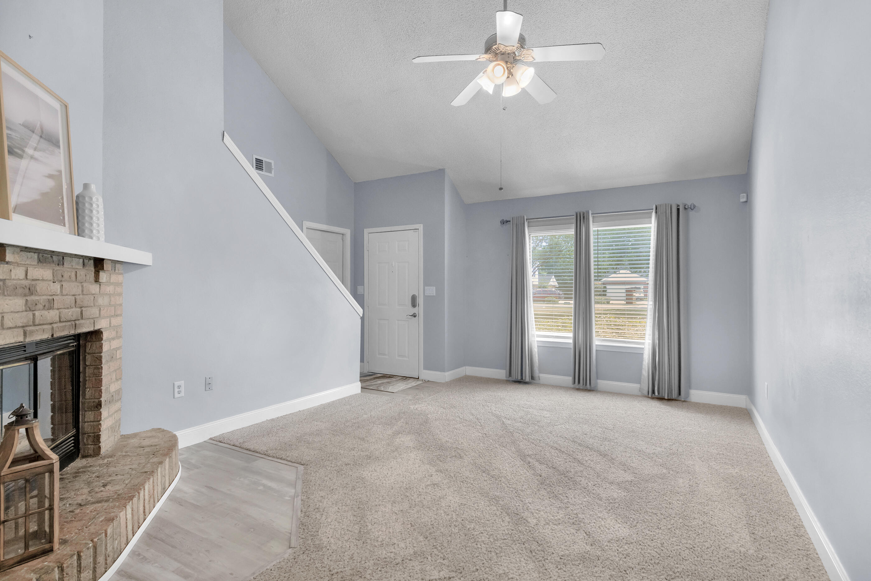 809 Valley Road Crestview, FL 32539 - Photo 8 of 24 a view of a livingroom with a fireplace a ceiling fan and windows