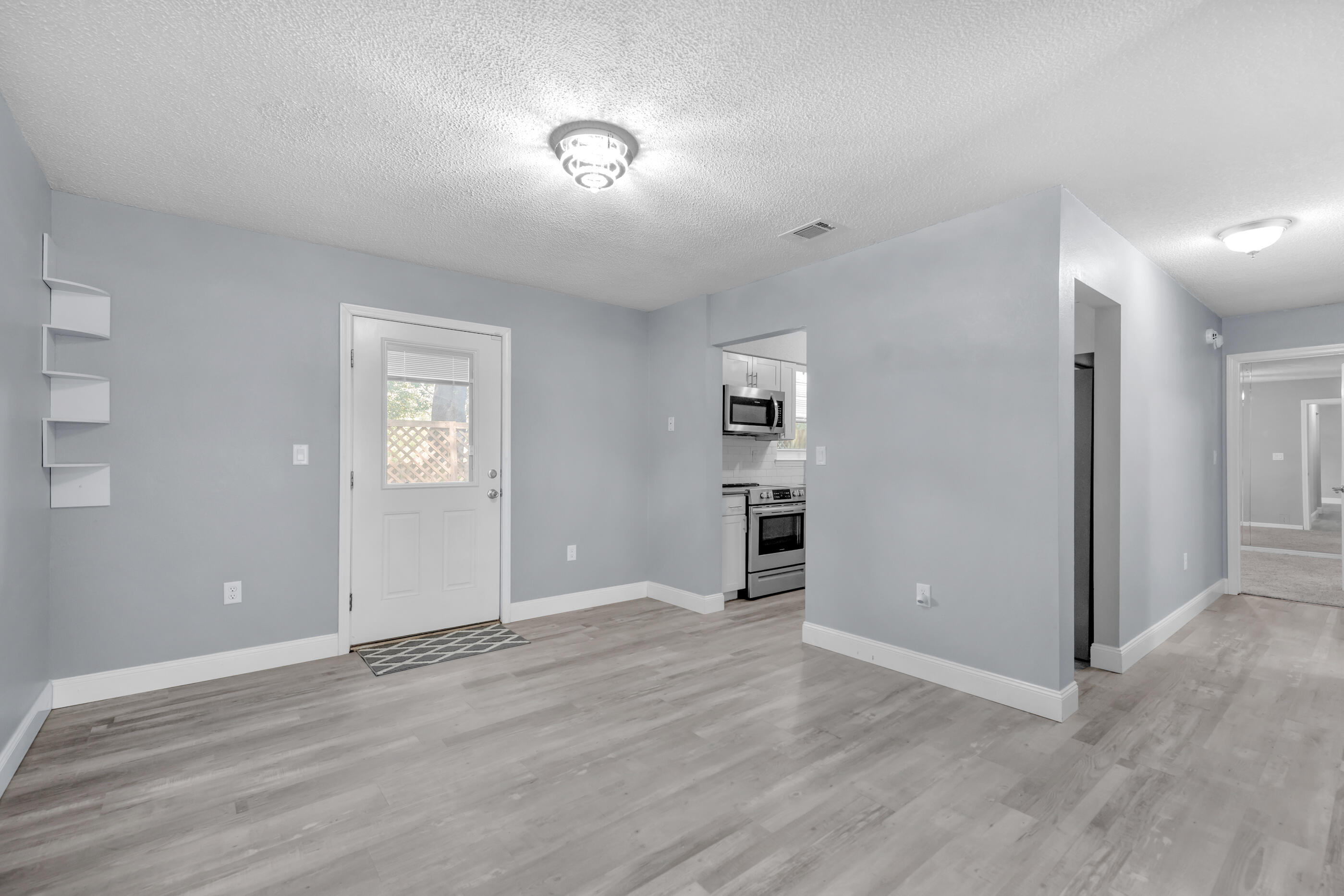 809 Valley Road Crestview, FL 32539 - Photo 10 of 24 an empty room with wooden floor and windows