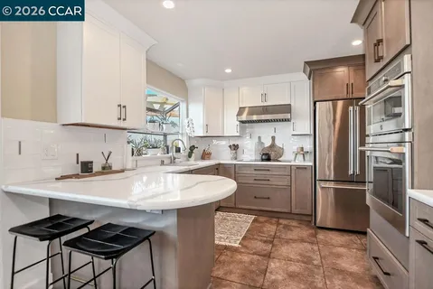 a kitchen with a sink stainless steel appliances and white cabinets