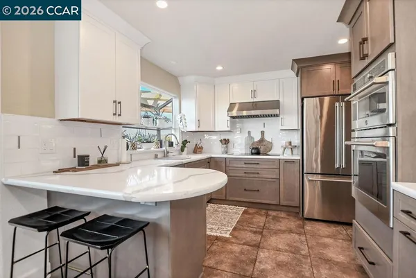 a kitchen with a sink stainless steel appliances and white cabinets