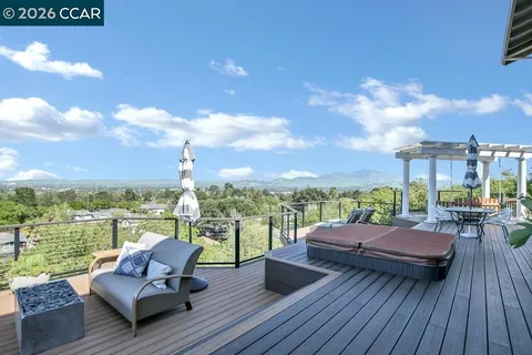 a view of a patio with couches chairs and city view