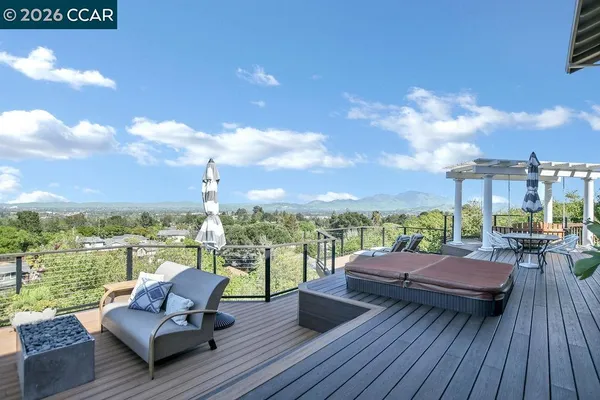 a view of a patio with couches chairs and city view