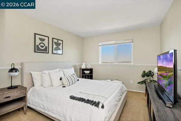 a bedroom with a bed and a flat screen tv