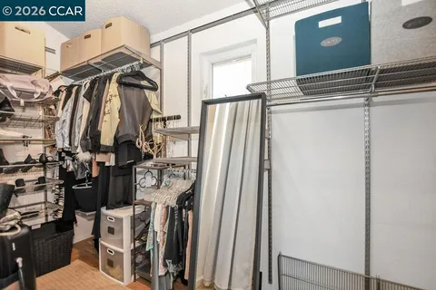 a view of walk in closet with clothes and shoes