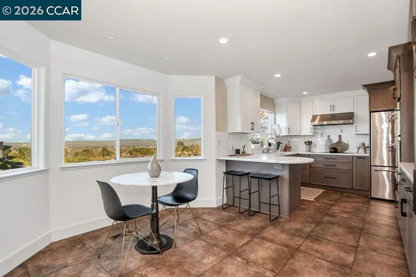 a kitchen with a table chairs sink and cabinets